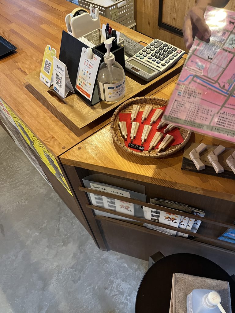 萩焼の店のレジ横。決済手段は一通りそろい、奥に手描きの地図がある